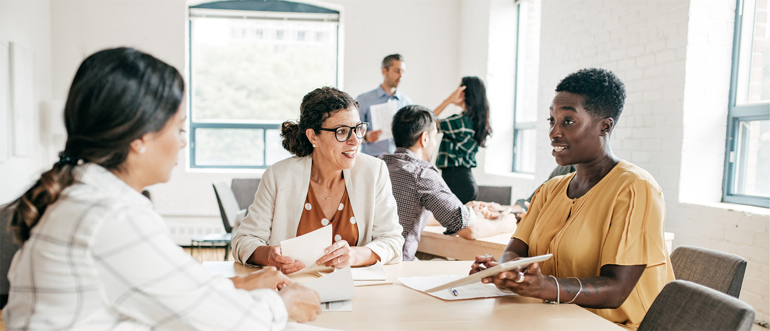 Teachers grading homework at a table together